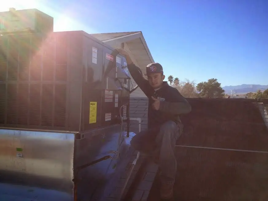 HVAC technician performing Heat Pump Repair on a rooftop unit in Davidson